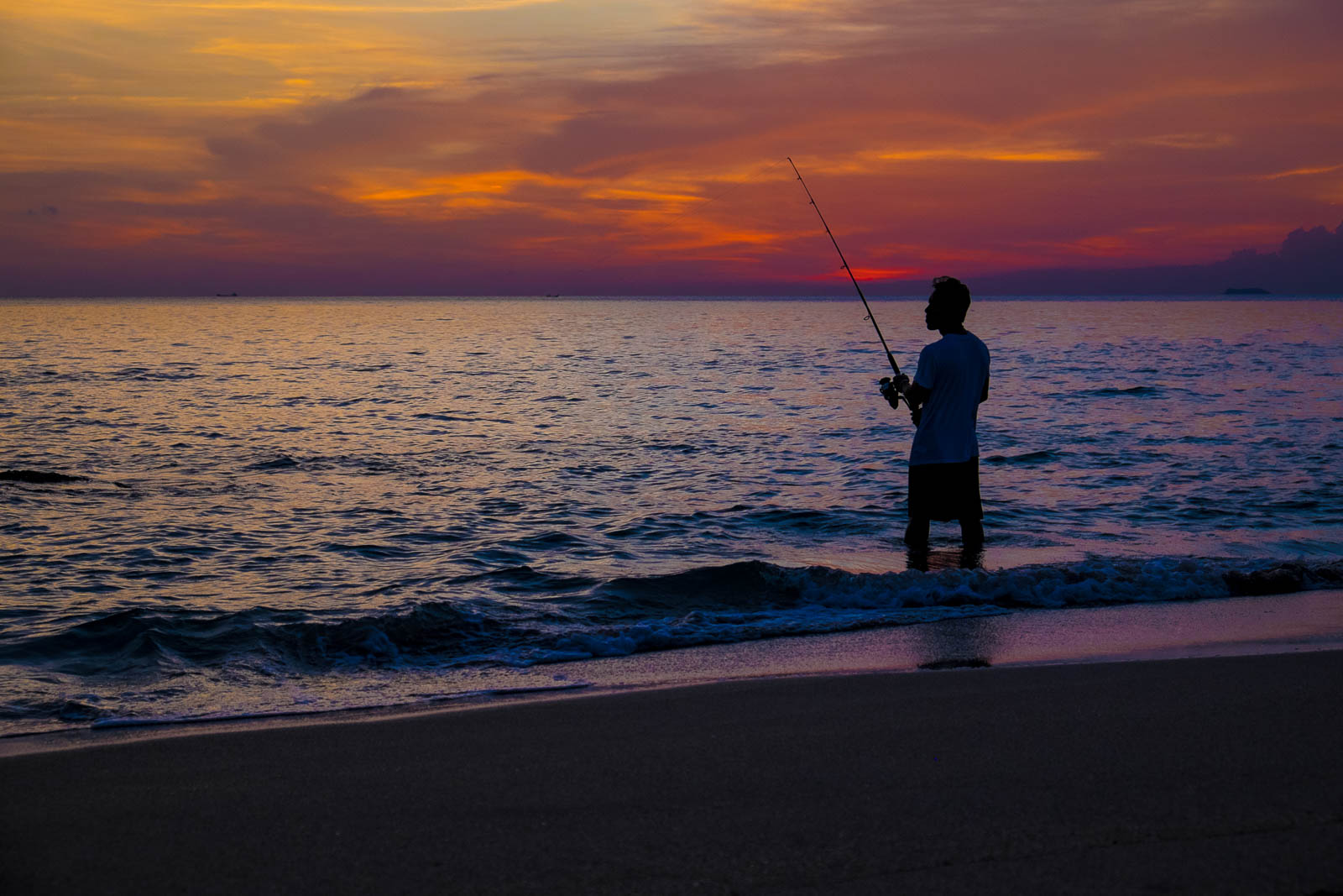 Angler on the beach during sunset on Ko Lanta, Thailand