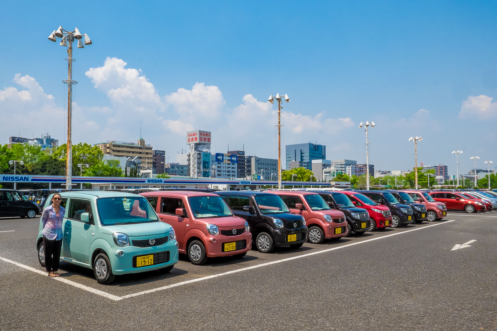 Uyla next to colorful, tiny Japanese cars